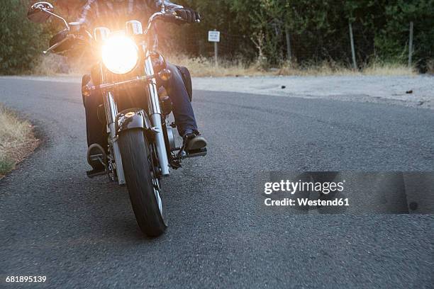 man riding motorbike on country road - motociclista fotografías e imágenes de stock