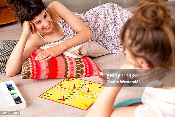 two best friends lying on the floor at home playing ludo - ludo stock pictures, royalty-free photos & images