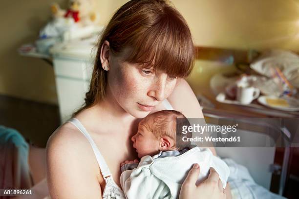 mother holding her newborn baby in hospital room - baby and mom fotografías e imágenes de stock