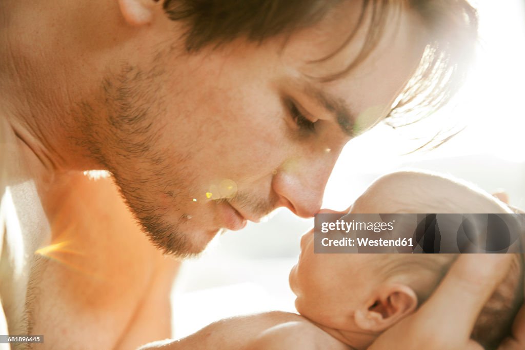 Father getting close to the face of his newborn baby