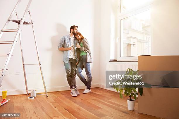 smiling young couple having a coffee break in new apartment - apartment stock-fotos und bilder