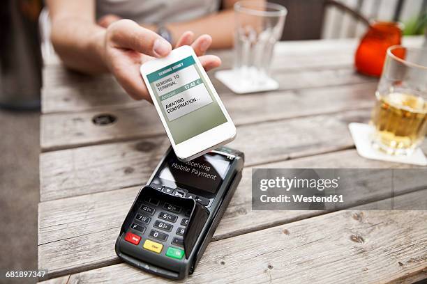 hand with smart phone mobile paying at a cafe - security screen stock pictures, royalty-free photos & images