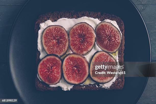 toasted rye bread with cream cheese, sliced figs and olive oil on on black plate - dark bread bildbanksfoton och bilder