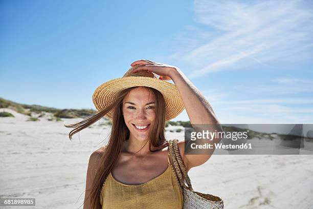 portrait of smiling young woman on the beach - sun hat stock pictures, royalty-free photos & images