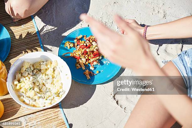 two friends on the beach having a salad - potato salad stock-fotos und bilder