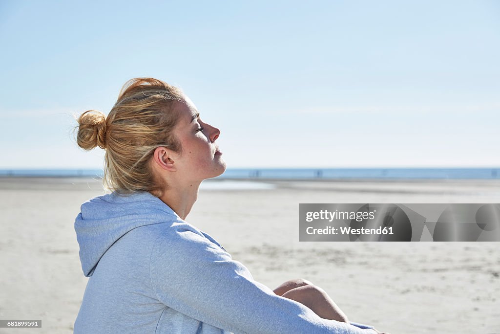 Young woman enjoying the sunshine on the beach