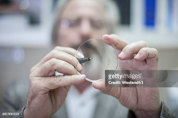 optometrist looking through eydeglass lens - looking through lens foto e immagini stock