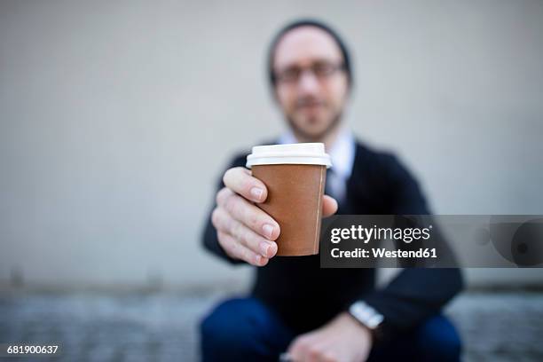 young man holding takeaway coffee - plastikbecher stock-fotos und bilder