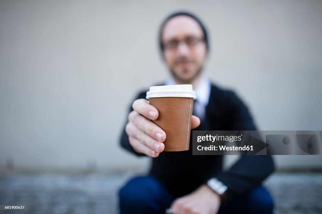 Young man holding takeaway coffee