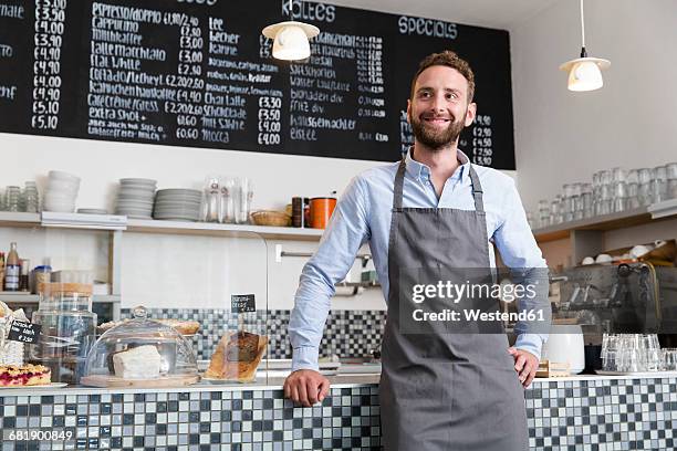 smiling barista in a cafe - schürze stock-fotos und bilder