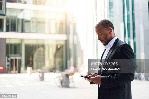 businessman using mini tablet - schwarzer mantel stock-fotos und bilder