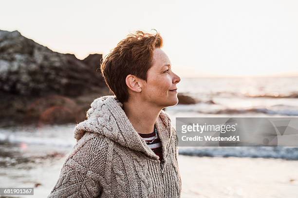 france, crozon peninsula, portrait of woman on the beach at sunset - smiling controluce foto e immagini stock