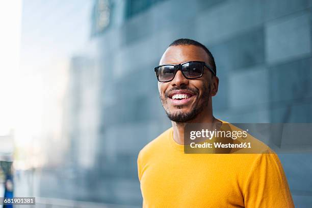 portrait of smiling man wearing yellow pullover and sunglasses - yellow sunglasses stock pictures, royalty-free photos & images