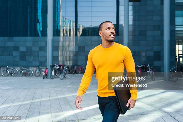 young man with file wearing yellow pullover watching something - tenue soignée photos et images de collection