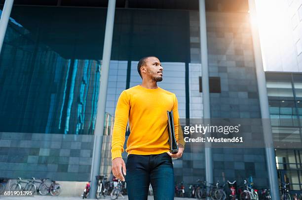 young man with file wearing yellow pullover - three quarter length stock pictures, royalty-free photos & images