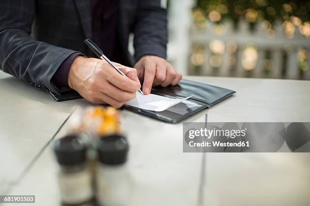 businessman signing the bill at restaurant - restaurant bill stock-fotos und bilder