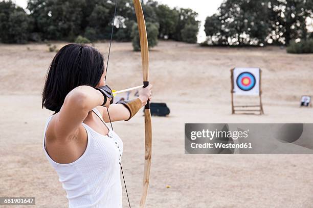 archeress aiming at target - arrow bow and arrow stockfoto's en -beelden