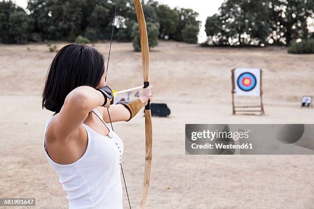 archeress aiming at target - archery stock pictures, royalty-free photos & images