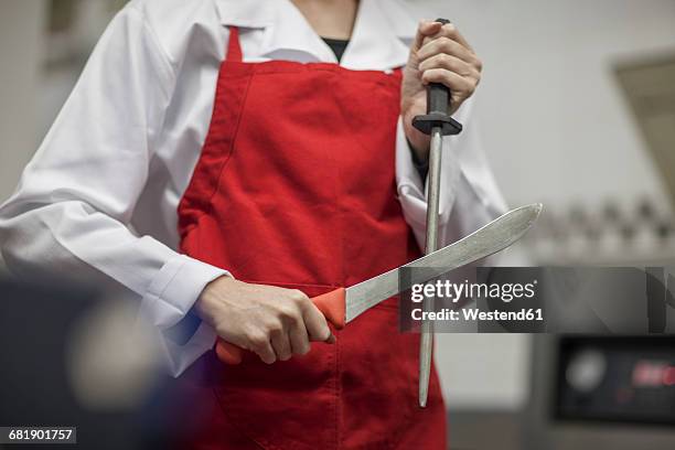 butcher sharpening his knife - carnicero fotografías e imágenes de stock