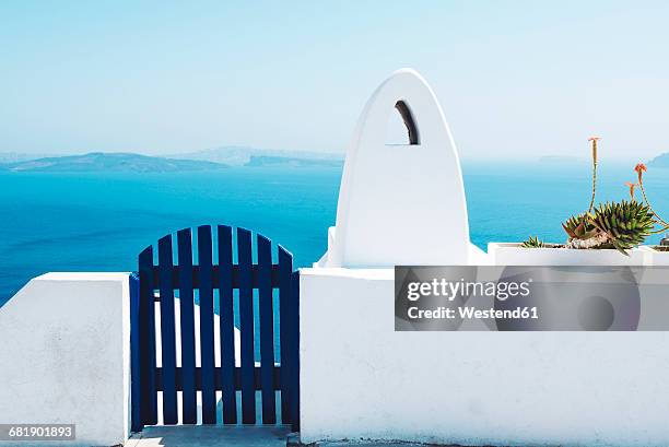 greece, santorini, oia, gate and chimney in front of the sea - whitewashed photos et images de collection