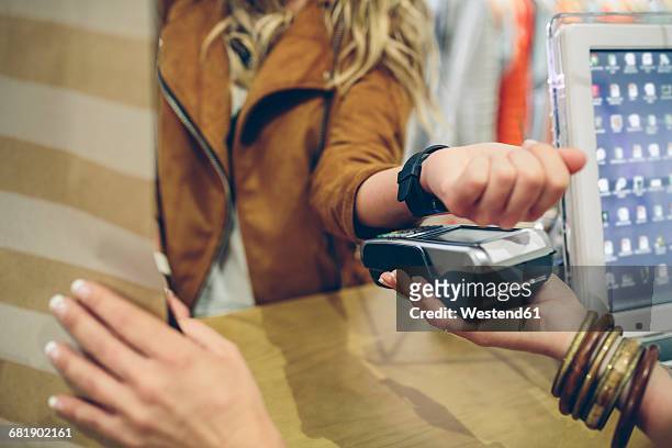 Woman paying using smartwatch with NFC technology in a store
