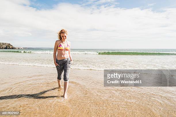 teenage girl wading in the sea - ankle deep in water - fotografias e filmes do acervo