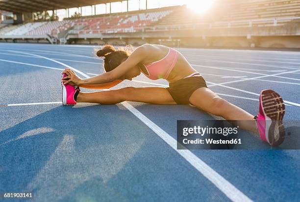 female athlete stretching in stadium - 陸上競技場 ストックフォトと画像