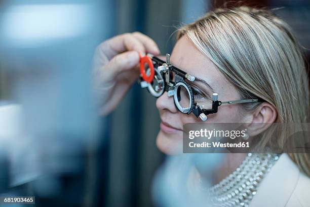 optometrist adjusting test frame for patient - esame oculistico foto e immagini stock