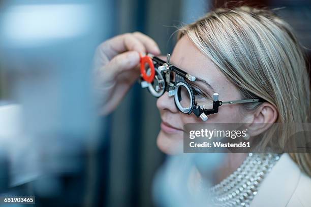 optometrist adjusting test frame for patient - eye test stock pictures, royalty-free photos & images
