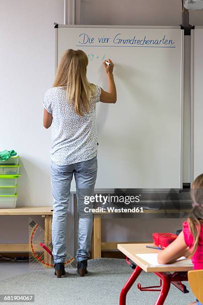 back view of teacher writing on whiteboard - whiteboard writing stock pictures, royalty-free photos & images