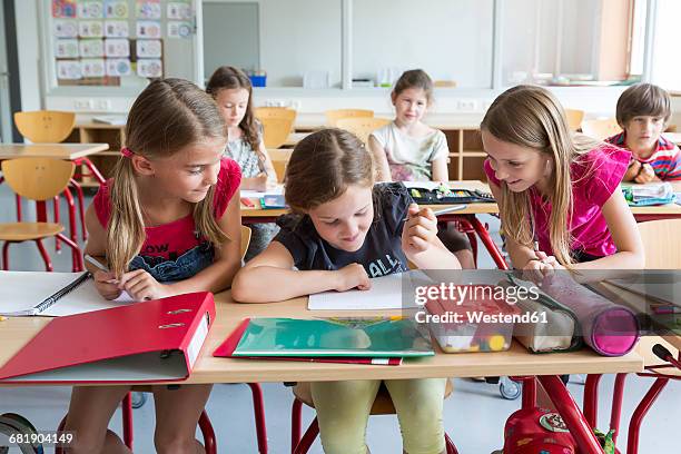 three schoolgirls at class - child in classroom stock-fotos und bilder