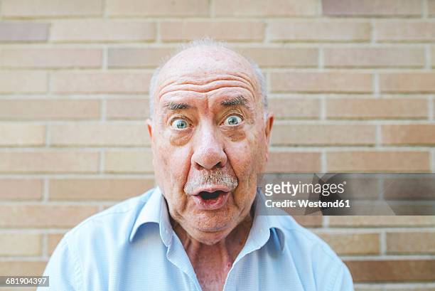 portrait of senior man pulling funny faces - grimacing 個照片及圖片檔