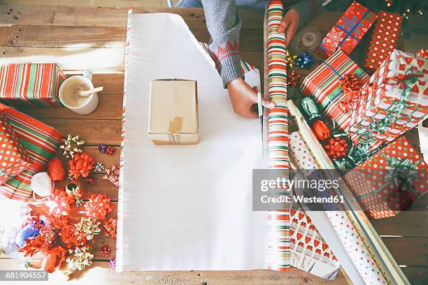 woman cutting wrapping paper for christmas gifts - wrapping paper stock photos et images de collection