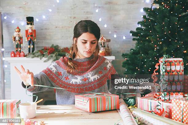 woman wrapping christmas gifts - lint strik stockfoto's en -beelden