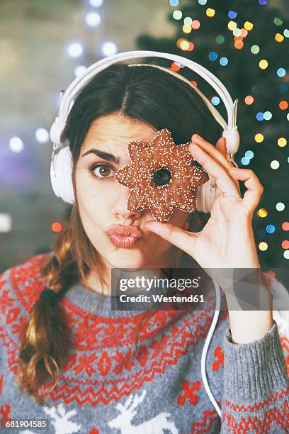 woman with headphones looking through a christmas cookie - christmas music listen stock pictures, royalty-free photos & images