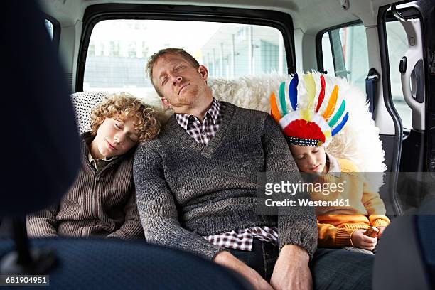 sleeping father sitting in car on back seat with his sons - family inside car - fotografias e filmes do acervo