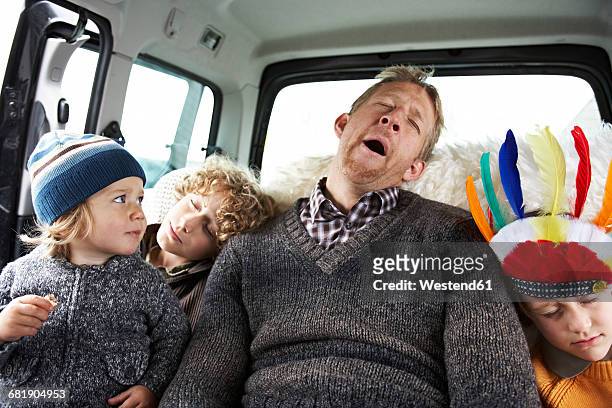 sleeping father sitting in car on back seat with his sons - rijden een motorvoertuig besturen stockfoto's en -beelden