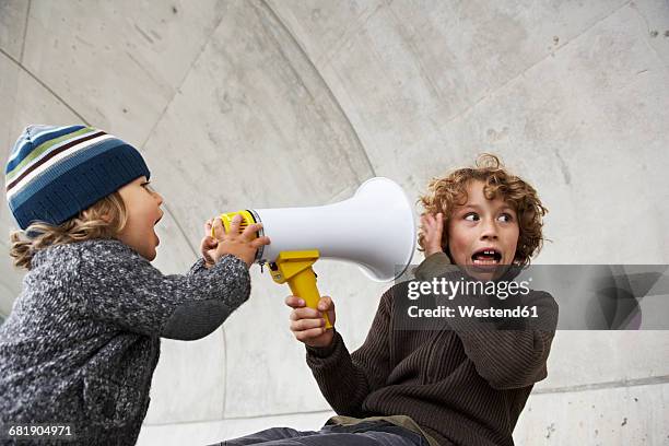 two brothers playing with a megaphone - kommunikationsproblem stock-fotos und bilder