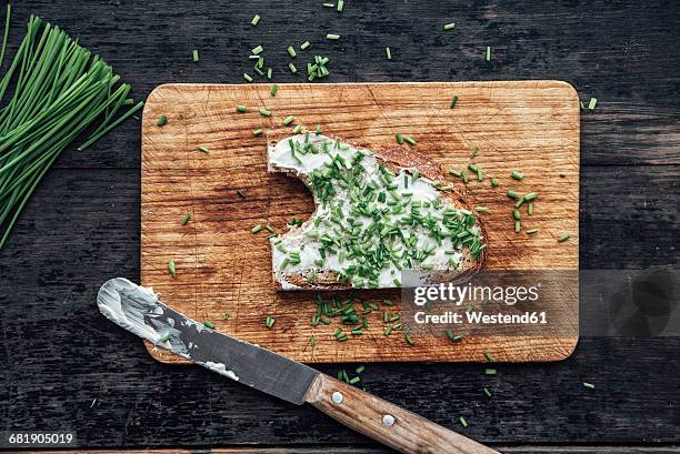 buttered bread with chives on chopping board - frühstück von oben stock-fotos und bilder