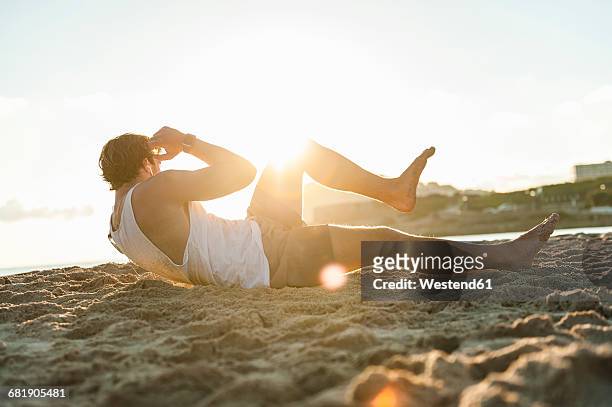 spain, mallorca, jogger at the beach at sunrise, situps - sit up foto e immagini stock
