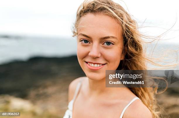 portrait of smiling blond teenage girl at the coast - long blonde hair in the wind stock pictures, royalty-free photos & images