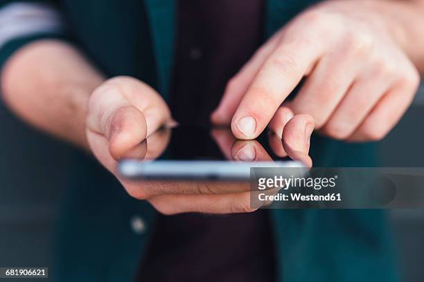index finger of young man touching smartphone - toccare foto e immagini stock