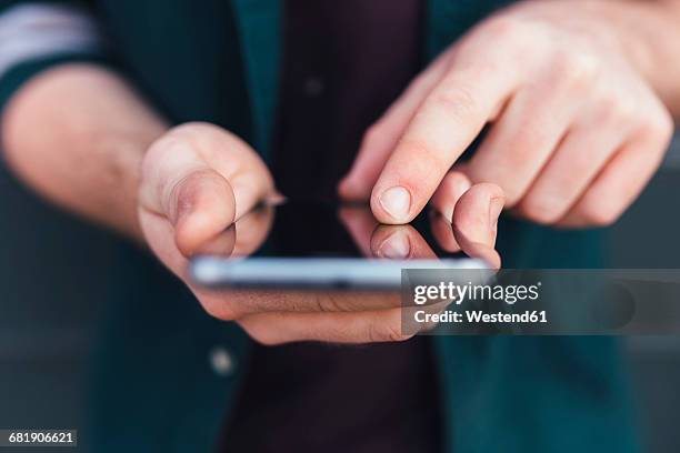 index finger of young man touching smartphone - man holding his hand out stock pictures, royalty-free photos & images