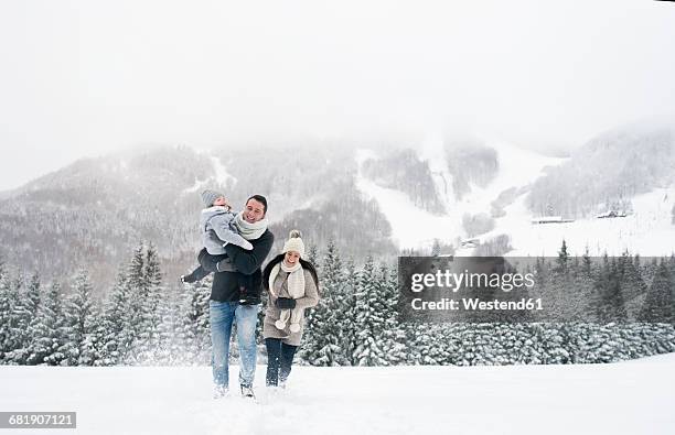 happy family walking in winter landscape - family snow holiday stock pictures, royalty-free photos & images