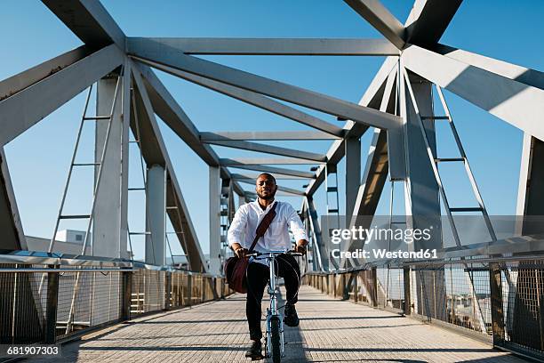 man riding bicycle on a bridge - velofahren stock-fotos und bilder