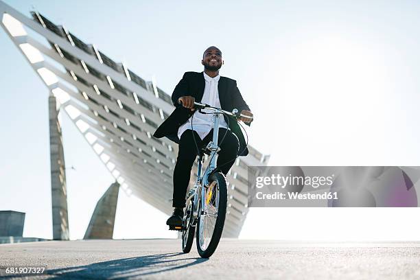 businessman riding bicycle at solar panels - businessman after work stock-fotos und bilder