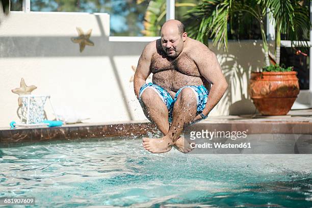 man jumping in swimming pool - jump in pool stockfoto's en -beelden