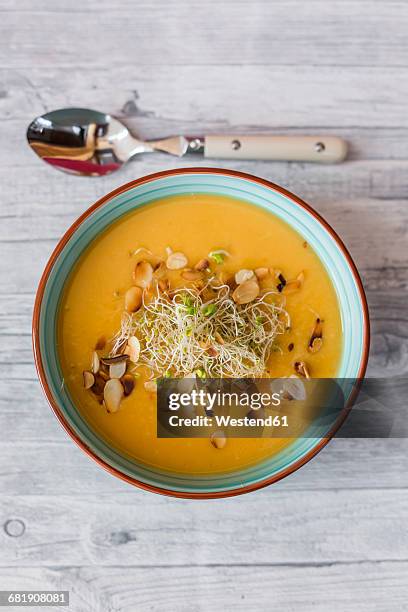 bowl of sweet potato coconut soup with ginger, parsnip, leek, sprout and almond - mashed sweet potato stock-fotos und bilder