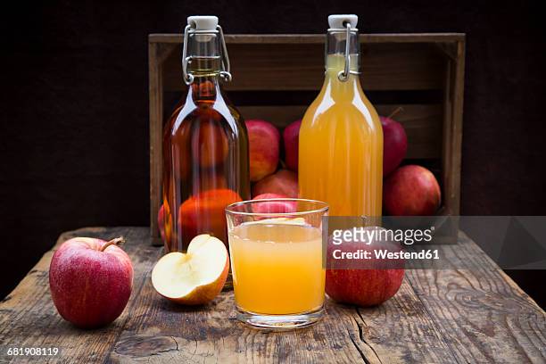 bottle and glass of apple juice, cloudy and clear, red apples on wood - apple juice stock pictures, royalty-free photos & images
