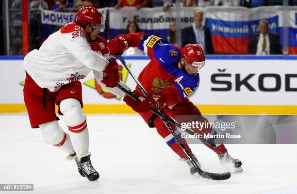 Sergei Andronov of Russia challenges Oliver Lauridsen of Denmark for the puck during the 2017 IIHF Ice Hockey World Championship game between Russia...